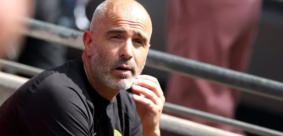 Entrenador observando desde la banca durante el partido