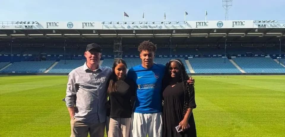 Jugador posando con familia en estadio de fútbol