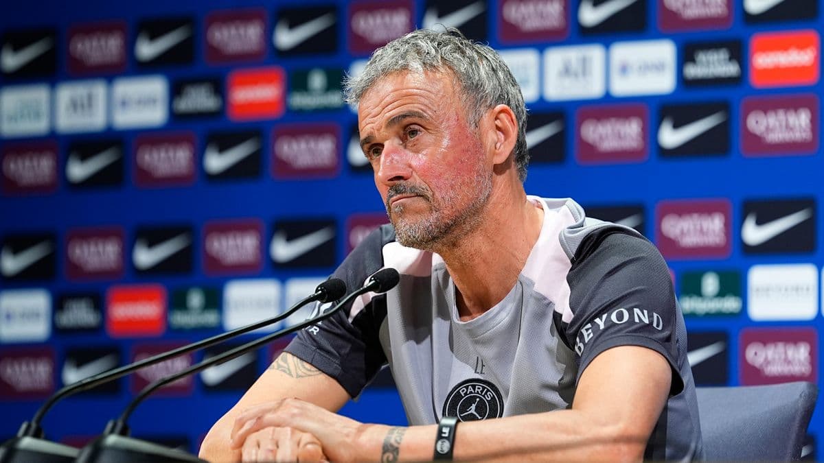 Entrenador en rueda de prensa con fondo patrocinador