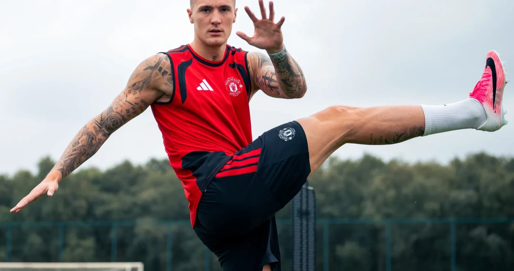 Jugador entrenando en campo de fútbol, levantando una pierna