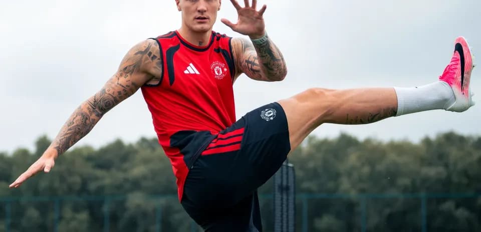 Jugador entrenando en campo de fútbol, levantando una pierna