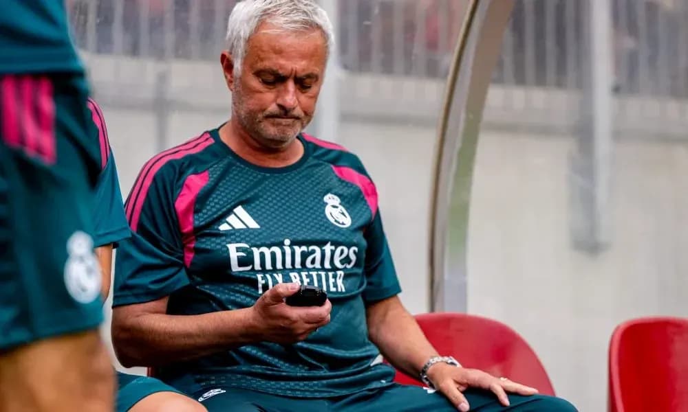 Entrenador revisando su teléfono en el banquillo