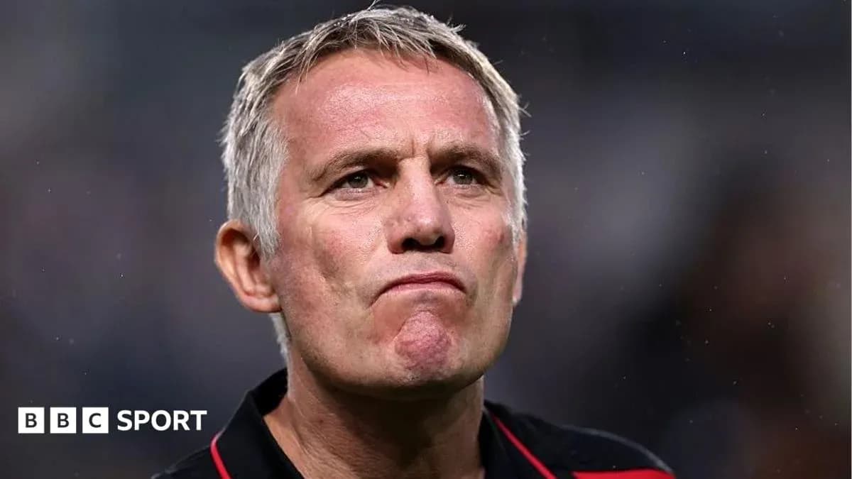 Entrenador mirando con expresión seria en el campo