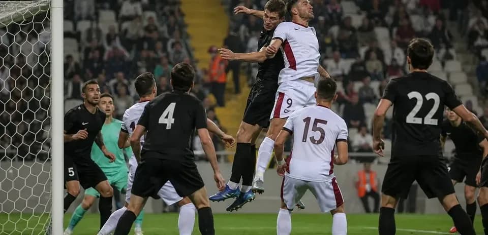 Jugadores saltando para cabecear el balón en el área