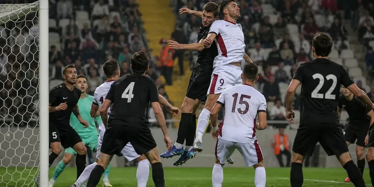 Jugadores saltando para cabecear el balón en el área