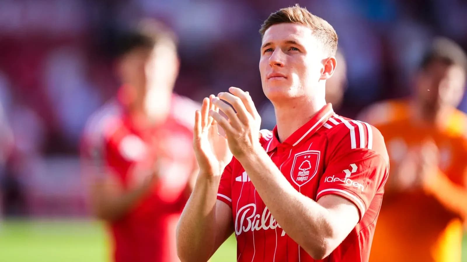 Jugador aplaudiendo en el campo con uniforme rojo