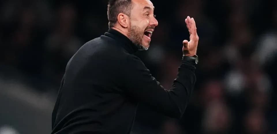 Entrenador gesticulando durante un partido de fútbol