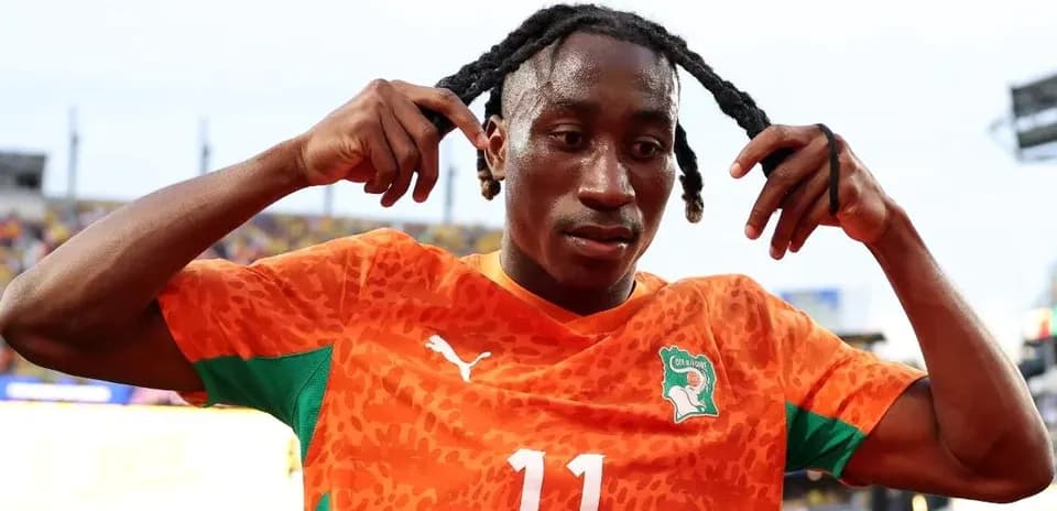 Jugador de fútbol con camiseta de Costa de Marfil ajustando su cabello