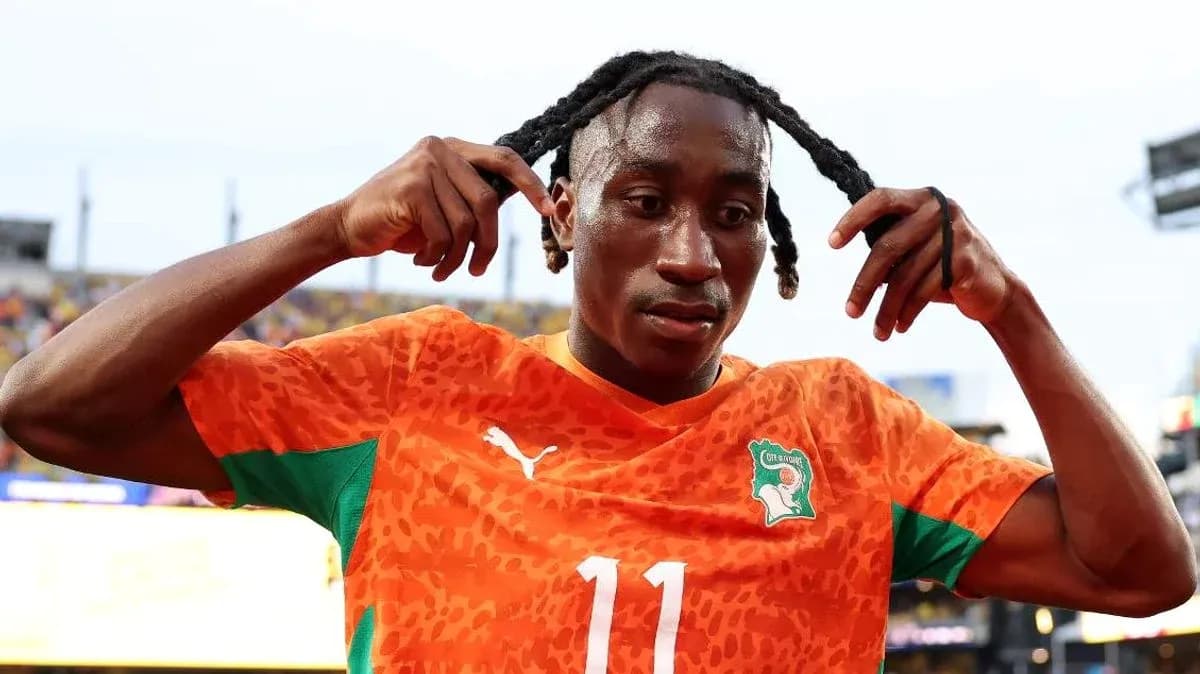 Jugador de fútbol con camiseta de Costa de Marfil ajustando su cabello
