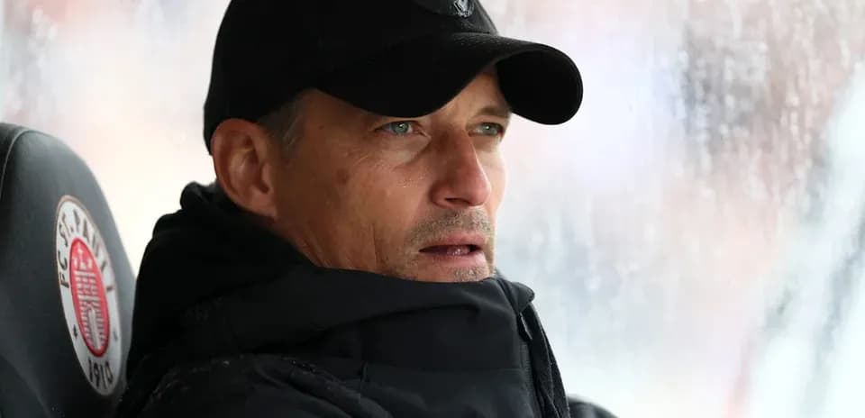 Entrenador observando desde el banquillo bajo la lluvia