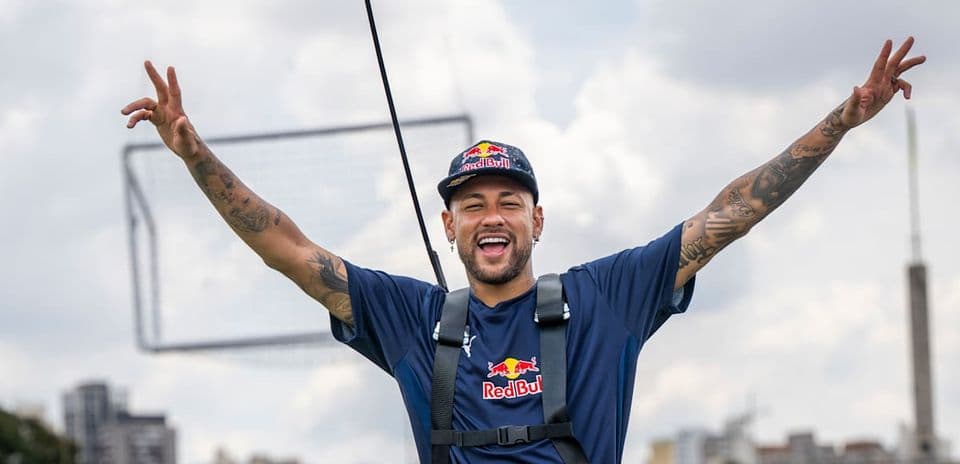 Neymar sonriente con brazos levantados en evento