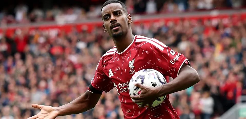 Jugador de Liverpool sosteniendo un balón en el campo