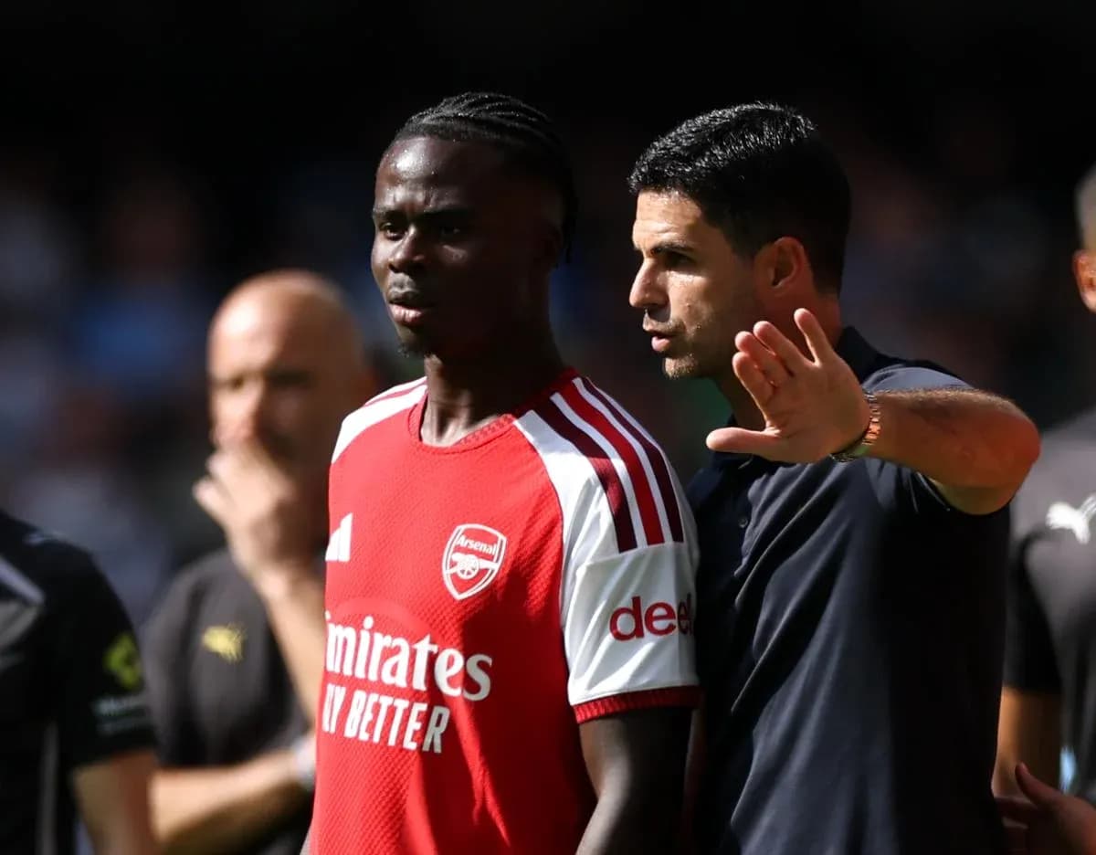 Entrenador de Arsenal hablando con jugador durante partido
