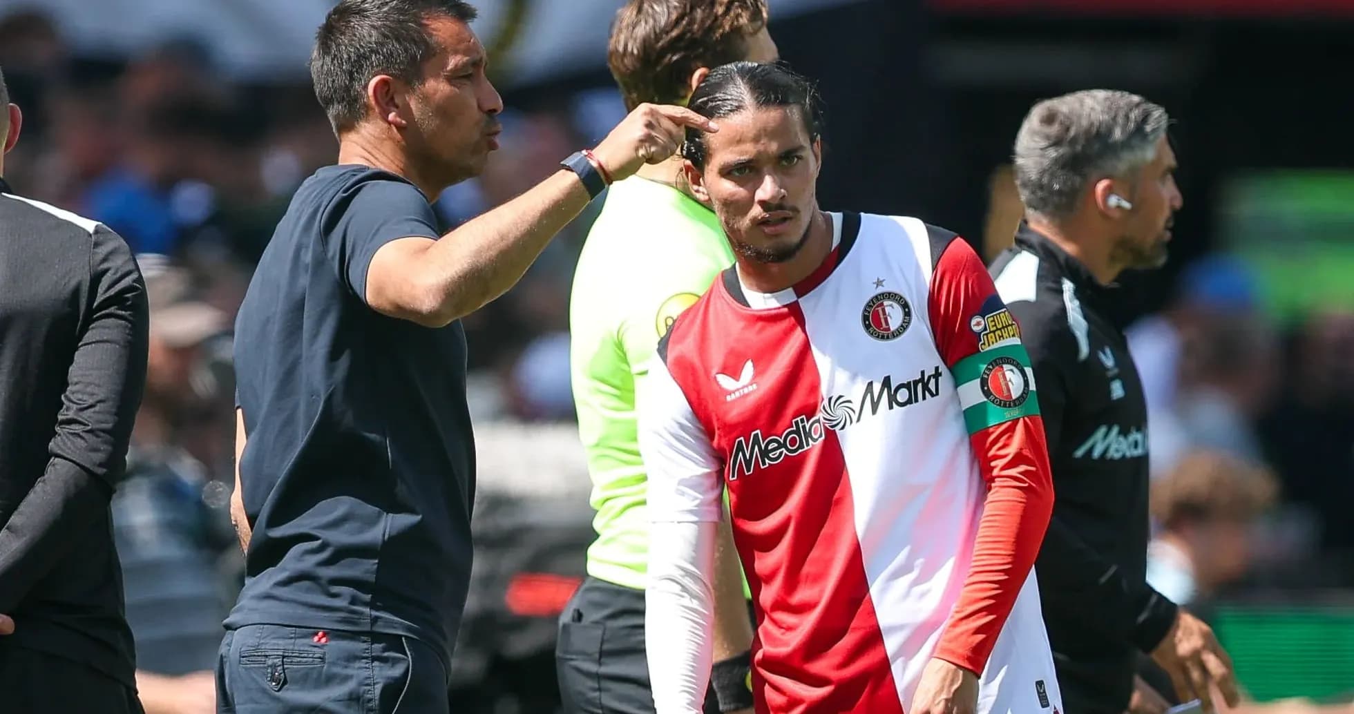 Entrenador hablando con jugador de Feyenoord en la banda