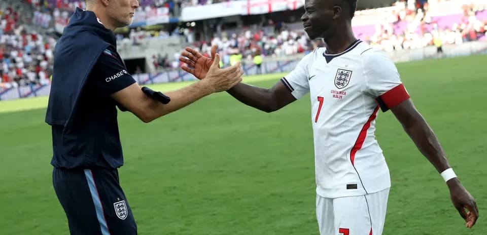 Entrenador y jugador de Inglaterra saludándose en el campo