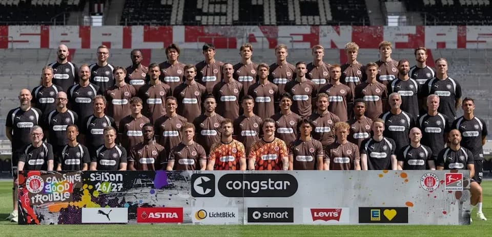 Equipo posando en el estadio con camiseta marrón