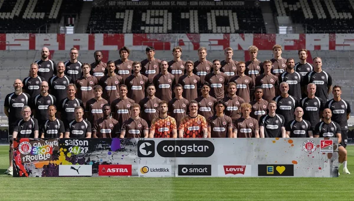 Equipo posando en el estadio con camiseta marrón
