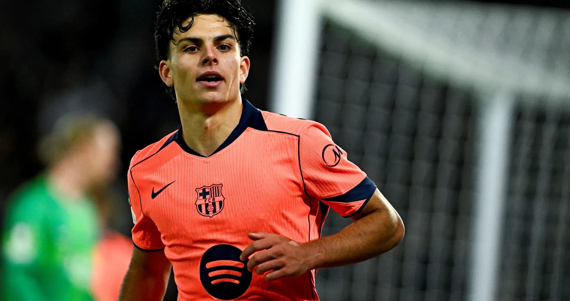 Jugador del FC Barcelona en uniforme naranja durante partido