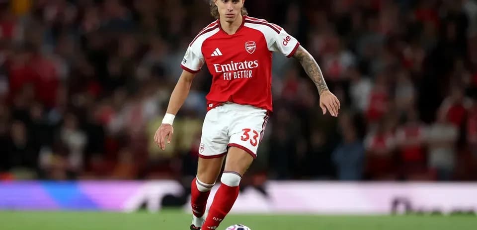 Jugador de Arsenal corriendo con el balón en el campo