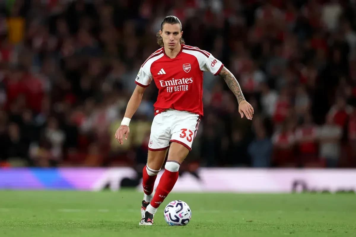 Jugador de Arsenal corriendo con el balón en el campo