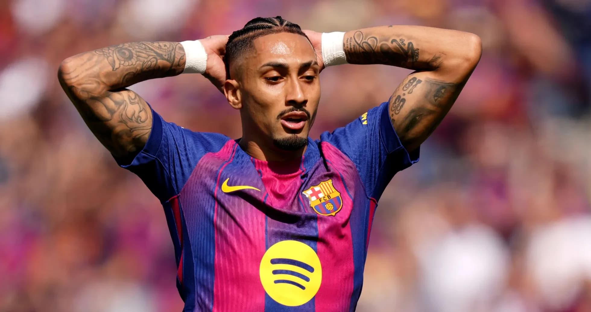 Jugador de Barcelona con brazos levantados en el campo