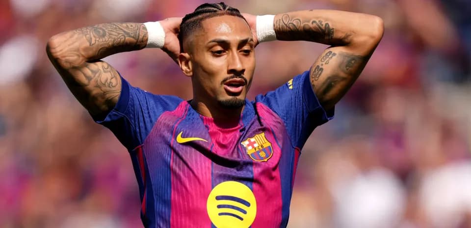 Jugador de Barcelona con brazos levantados en el campo