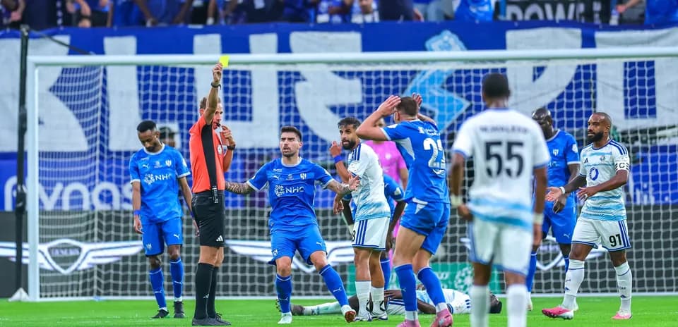 Árbitro muestra tarjeta amarilla a jugador durante partido
