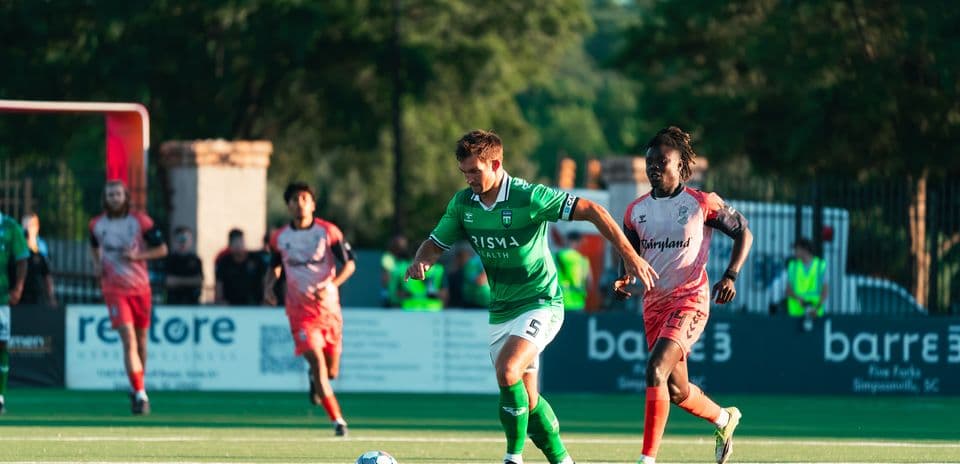 Jugador con balón en partido de fútbol
