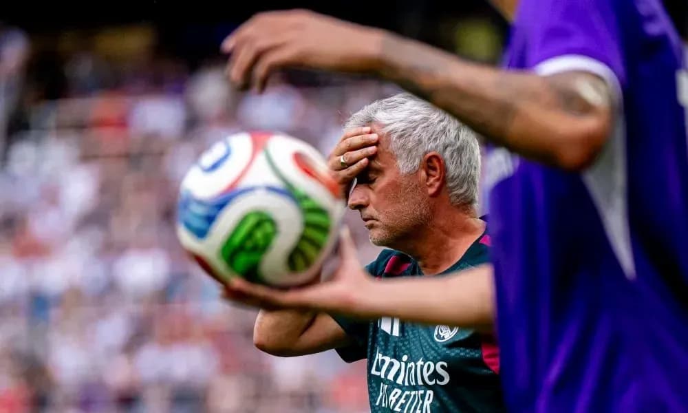 Entrenador tocándose la frente durante el partido