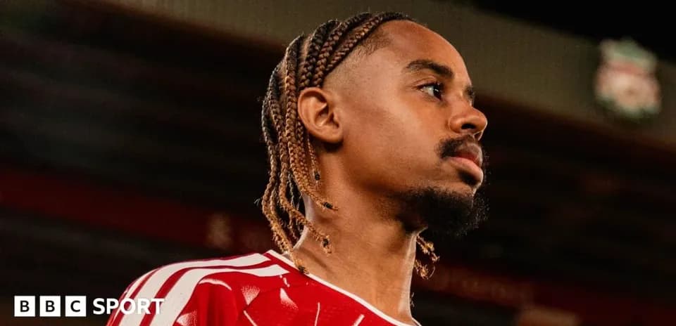 Jugador con trenzas en uniforme rojo en estadio