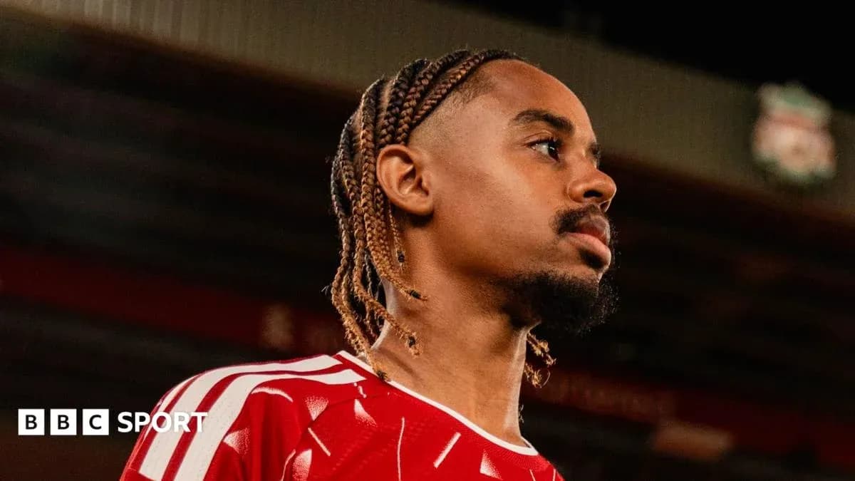 Jugador con trenzas en uniforme rojo en estadio