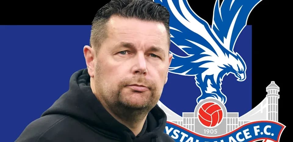 Entrenador de Crystal Palace frente a su escudo