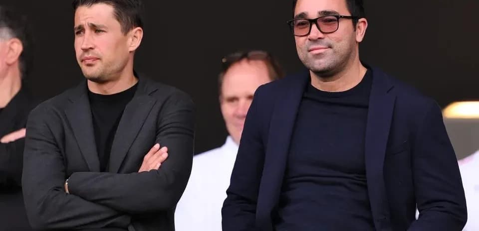 Dos hombres observando desde un palco en un evento