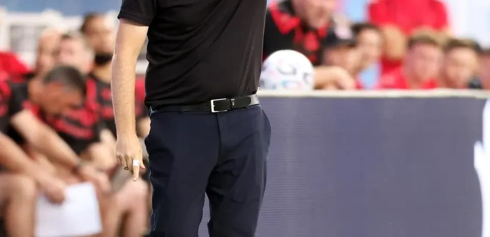Entrenador dirigiendo a su equipo desde la banda