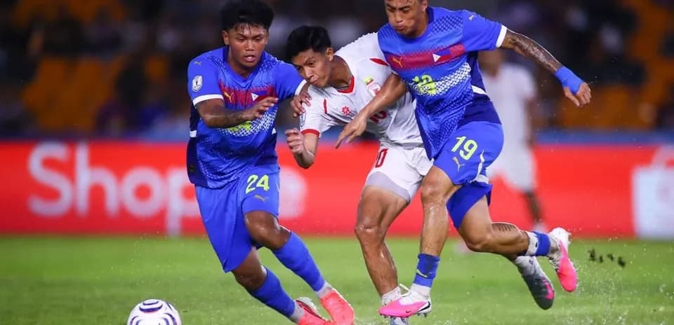 Dos jugadores defienden mientras un oponente avanza