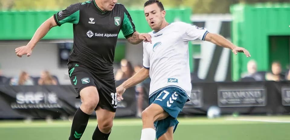Dos jugadores compitiendo por el balón en el partido