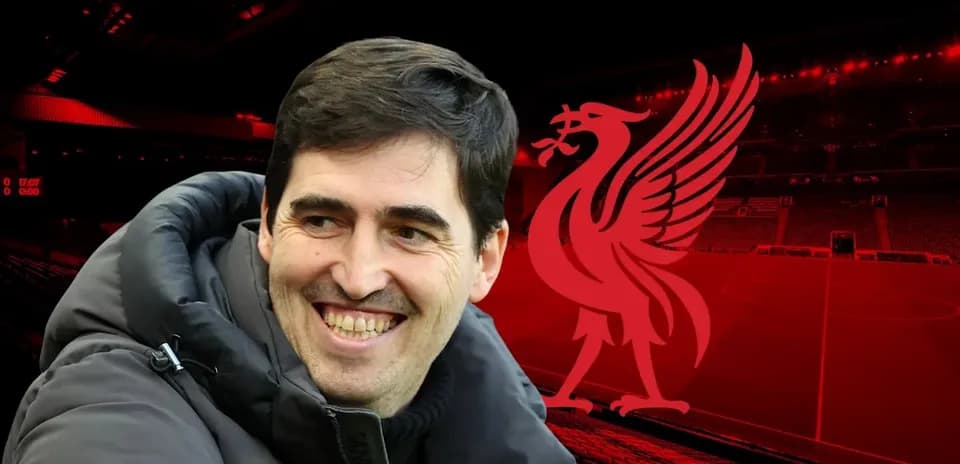 Entrenador sonriendo con fondo del estadio de Liverpool