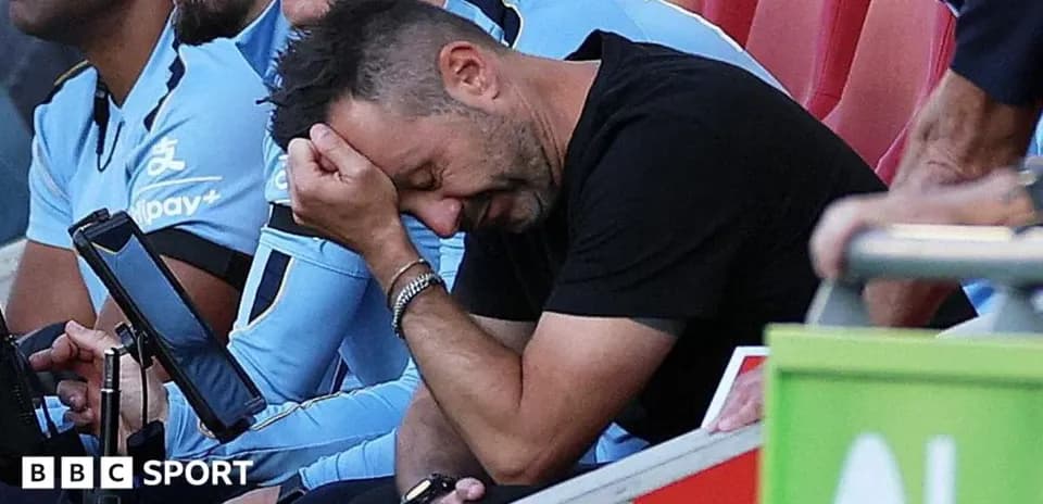 Entrenador con la cabeza entre las manos en el banquillo