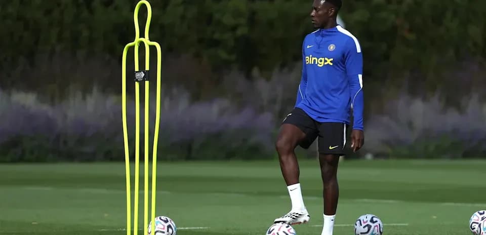Jugador entrenando con conos y balones en campo