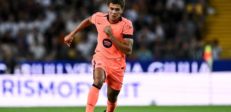 Jugador corriendo en camiseta rosa durante el partido