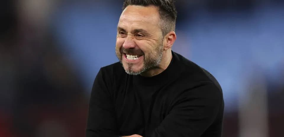 Entrenador sonriendo durante un partido
