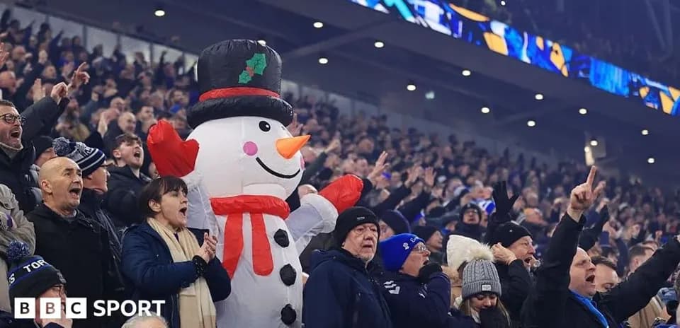 A large snowman costume among cheering fans