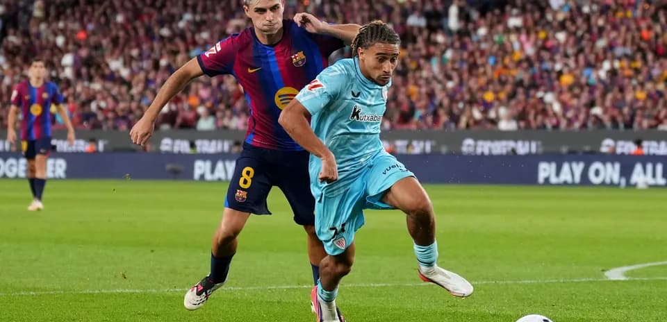 Jugador del Barcelona persiguiendo a oponente en el campo
