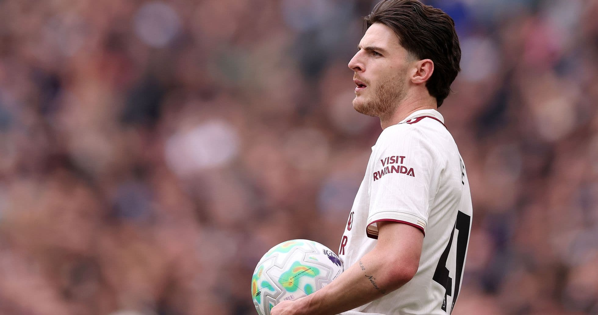 Jugador sosteniendo el balón en el campo de juego
