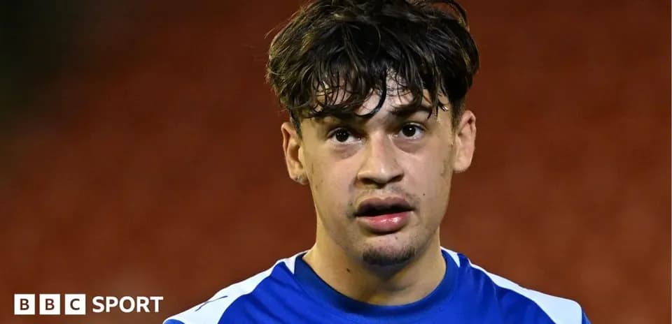 Jugador de fútbol con camiseta azul en el campo