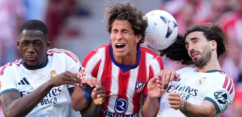 Jugadores de Atlético y Real Madrid luchando por el balón
