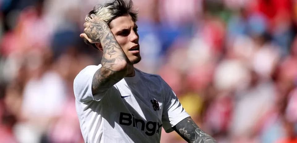 Jugador con camiseta blanca tocándose el cabello en el campo
