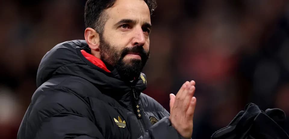 Entrenador aplaudiendo desde la banda del estadio
