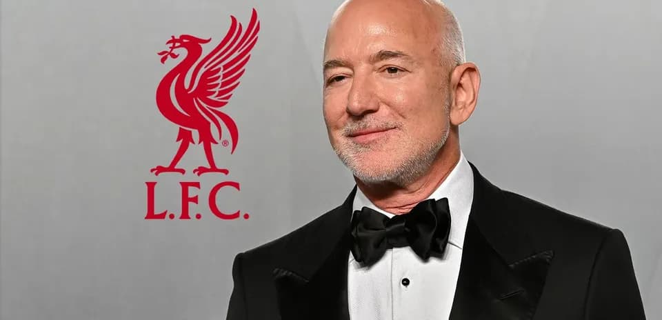 Hombre con traje formal junto al logo de Liverpool