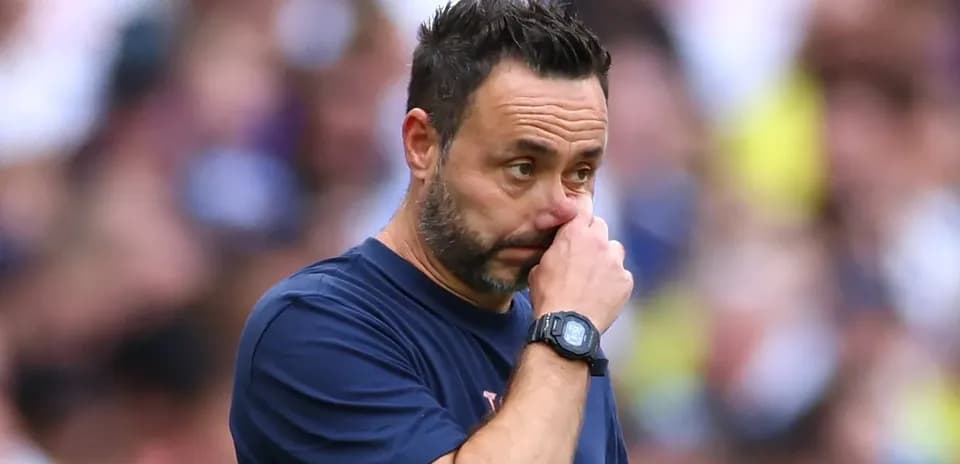 Entrenador con mano en la cara durante partido